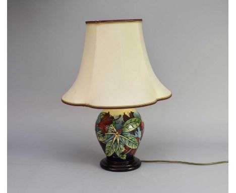 A contemporary Moorcroft table lamp in the 'Simeon' pattern, of baluster form, typically tubelined with the red flowers and g