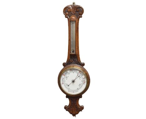 A late Victorian carved oak aneroid 'banjo' barometer, with thermometer having silvered indices, the barometer with printed 7