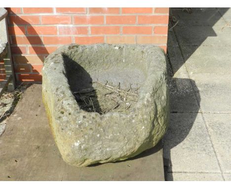 A large carved stone garden trough, 19th century, weathered to a broadly ovoid shape with rectangular interior, 77cm long, 70