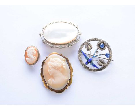 Two oval shell cameo brooches, together with a silver mounted mother of pearl brooch and a white metal, blue paste and enamel