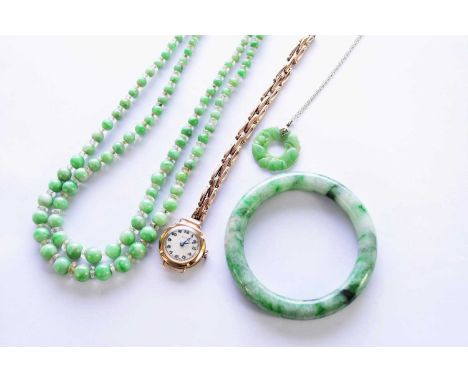A jade bangle, together with a two strand jade bead necklace, a carved jade pendant, a 9ct gold Texa bracelet wristwatch (at 