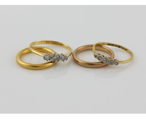 Four gold rings, 1930's wedding band, in 22 ct, hallmarked London 1932, size K, with a diamond three stone ring, set with thr