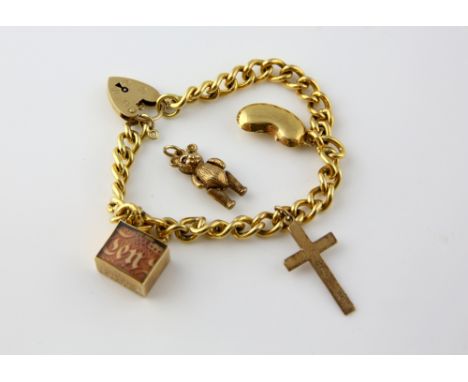 Vintage charm bracelet, curb link bracelet with heart pad lock clasp, hallmarked London 1972, and attached cross, bean, emerg