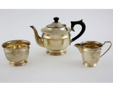 George VI silver three piece round ea service of plain form the teapot with ebonised knob and handle, Sheffield 1938, makers 