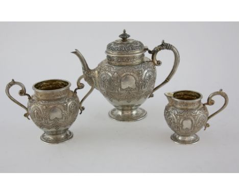 George V Scottish silver tea service, comprising tea pot, cream jug and sugar bowl, with embossed figural and scrolling decor