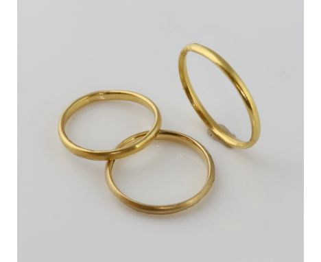 Three gold wedding bands, one hallmarked London 1952, size K, with matching wedding band, ring size Q, both in 22 ct yellow g