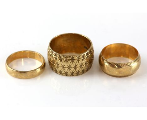 Three gold rings, vintage wide ring engraved with star pattern, hallmarked London 1967, size P,  a wedding ring, with an engr