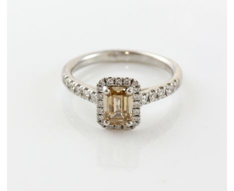 Fancy coloured diamond ring the central step cut stone, cognac, slightly pink, estimated at 1.00 carat, within a border of sm