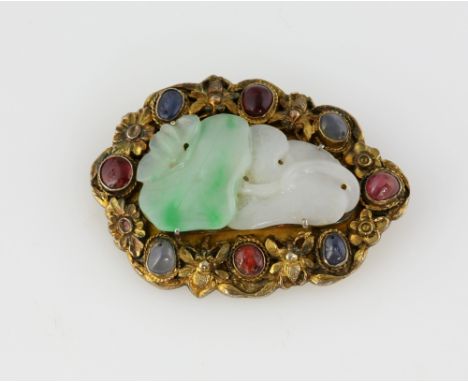 Jade, sapphire and ruby brooch, central jadeite jade carved in floral motif, surrounded by four cabochon cut sapphire and fou