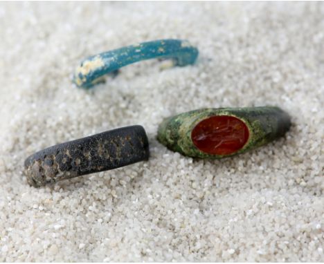 Roman & Byzantine period rings, bronze ring with oval carnelian intaglio depicting a figure, similar period glass ring and an