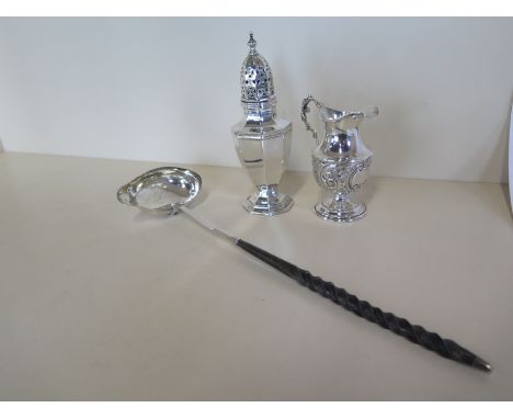A silver cream jug, a silver caster and a silver ladle, total weigh-able silver approx 4.8 troy oz, wear and repair to ladle,
