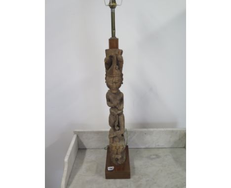An Oriental carved figure adapted to a table lamp, figure height 60cm, cracks and wear to body, minor losses, lamp needs wiri