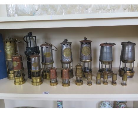 A collection of assorted miners lamps including miniature lamps seventeen in total - and an edition of 'The Miners Flame Ligh