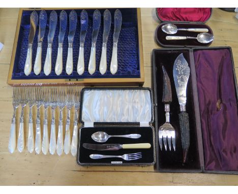 Nine silver and mother of pearl fish knives and forks in an associated box, two silver and mother of pearl spoons, boxed - a 