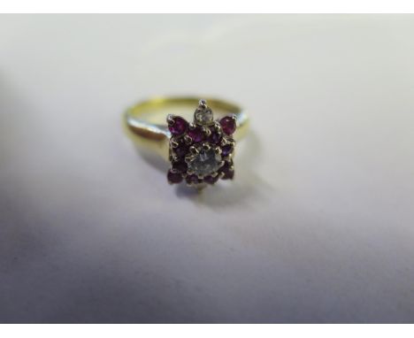 An 18ct yellow gold diamond and ruby cluster ring - size M, approx 4.8 grams, the central diamond approx 0.20ct - diamonds br