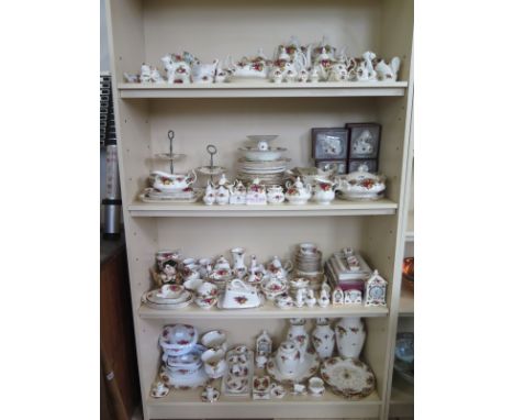 A large collection of Royal Albert Country Rose dinner and tea ware, including ornaments, tea and coffee ware vases, a clock 