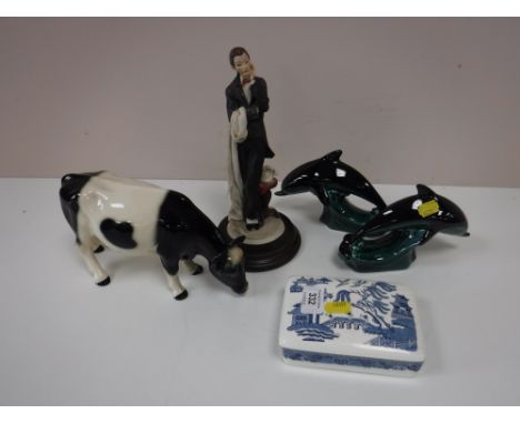Two Poole dolphins, a continental figure, china figure of a fresian cow, a Wedgwood trinket dish 