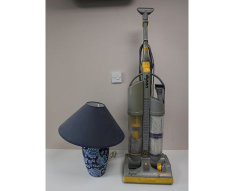 A Dyson DC 3 upright vac cleaner and a pottery table lamp with shade 
