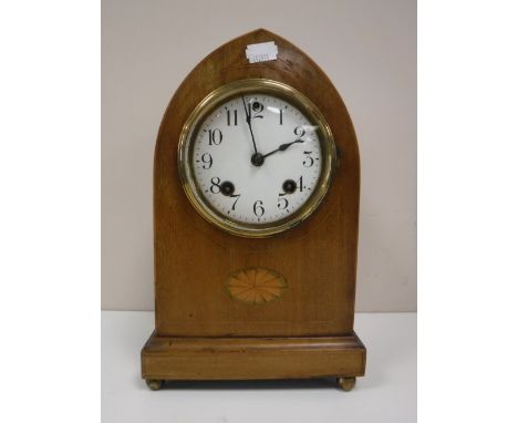 An inlaid mahogany domed topped mantel clock on brass feet 