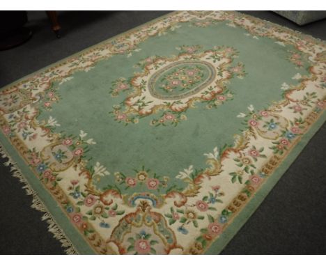A Chinese fringed carpet on green ground, 268cm x 360cm