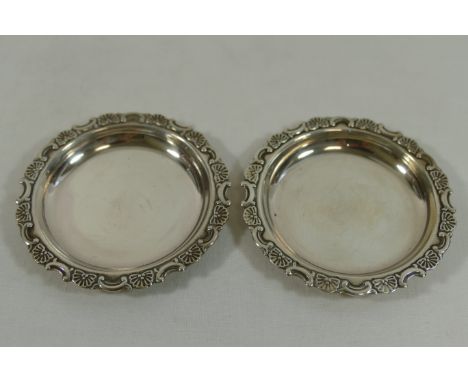 A pair of small Japanese silver coloured metal circular dishes, by K Uyeda, with scroll and fan moulded rim, maker's mark to 