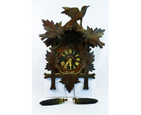 A 20th century Black Forest cuckoo clock, of typical bird and leaf form, stamped 'Foreign' to the dial, 49cm long CONDITION R