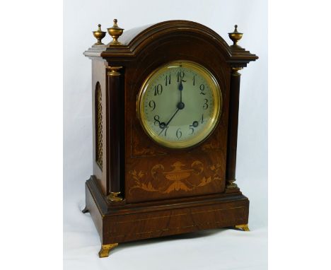 An early 20th century dome topped rosewood cased inlaid mantle clock, the silvered dial with Arabic numerals, with gilt brass