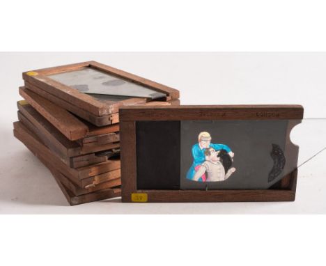 A group of eleven hand painted magic lantern glass slipping slides:, including a lion and strong man, a boy eating a pie at a