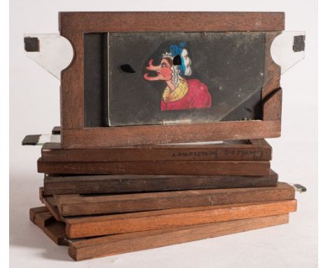 Six hand painted magic lantern glass slipping slides:, including a Chelsea Pensioner with three changing faces, Mr Punch with