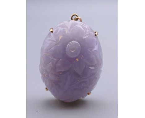 A 14 ct gold and carved lavender jade pendant. 4 cm high.
