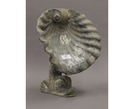 A lead garden ornament, modelled as a dolphin with a clam shell. 31 cm high.