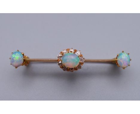 An unmarked gold diamond and opal bar brooch. 4 cm wide. 3 grammes total weight.