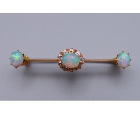 An unmarked gold diamond and opal bar brooch. 4 cm wide. 3 grammes total weight.