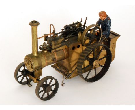 A spirit fired brass traction engine by D.R.M engineers Birmingham together with an associated driver, length 30cm 