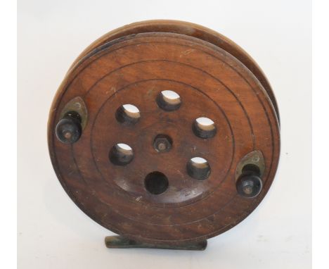A Victorian mahogany salmon fishing reel with ebony handles and brass mounts stamped Eton Sun, diameter 18cm.