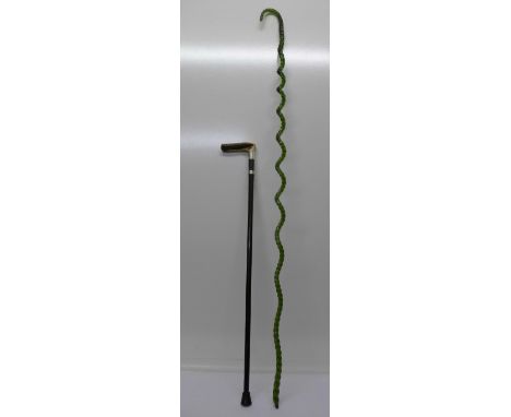 A walking stick with antler handle and a large long green twisted glass shepherd's crook