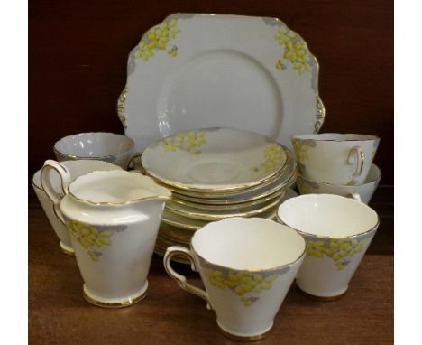 A six setting Art Deco tea service comprising a cake plate, six cups, saucers, side plates and cream, no sugar