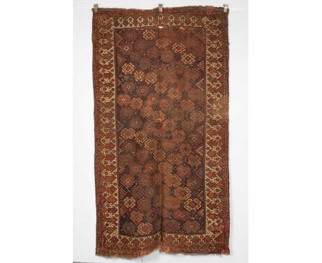 A Kurdish rug West Persia, late 19th Century, the indigo field of polychrome hooked medallions, framed by ivory and madder re