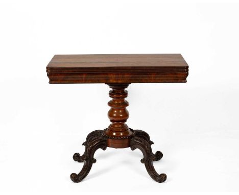 A Victorian mahogany card table, the fold over top with a plain frieze above a baluster turned column and scroll carved legs,