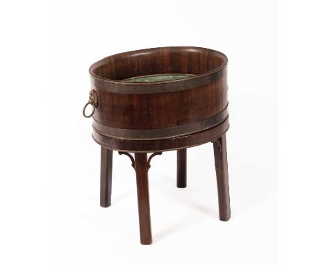 A George III style mahogany wine cooler, the oval upper section with lion mask ring handles, on a stand with four square cham