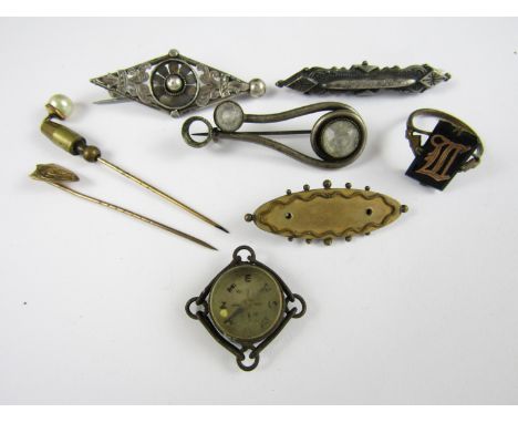 A Victorian yellow metal stick pin with shield shaped terminal, together with two Victorian white metal brooches etc