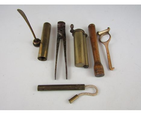 A quantity of vintage firearms related tools including a 12 gauge shotgun cartridge removal tool and a Lee Enfield oil bottle
