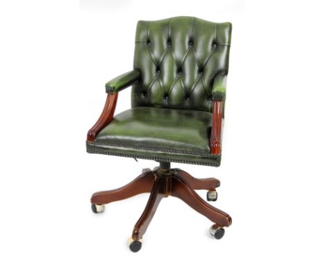 A 20thC swivel office chair, with button back, overstuffed arms and seat, on a five spoke base terminating in castors, 91cm H