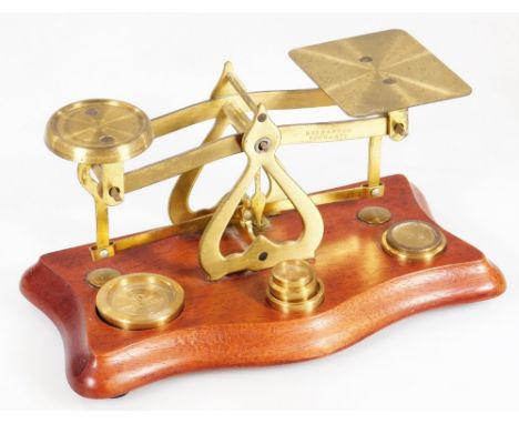A late 20thC postal scales, with serpentine base, brass articulated top and various weights, 18cm W.