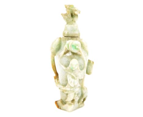 A Chinese green jade finish perfume bottle, with shaped lid, carved stylized lotus flower body headed by a figure and shaped 