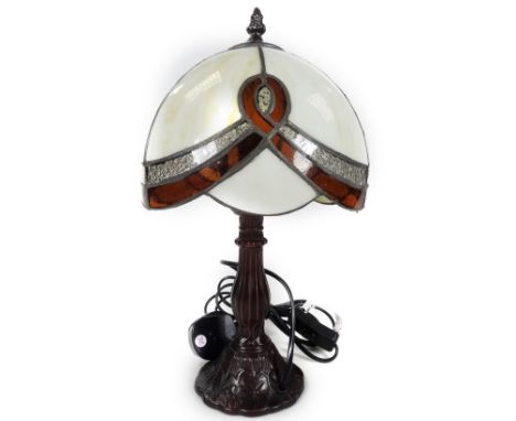 *An as new Minster table lamp, with Tiffany style domed shade predominately in cream and amber coloured glass, 32cm H.