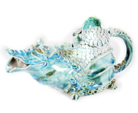A 20thC grotesque teapot, formed as a dragon, with removable lid, in green glazes, unmarked, 21cm H. 