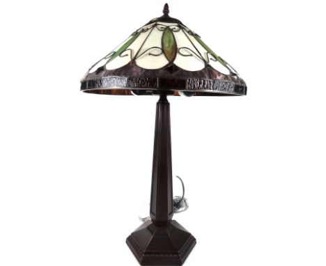 *An as new table lamp, with Tiffany style shade, with repeat pattern scroll design predominately in green, purple and cream, 