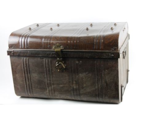 An early 20thC dome top tin trunk, partially painted in brown, with side carrying handles and plain interior, 45cm H, 68cm W,