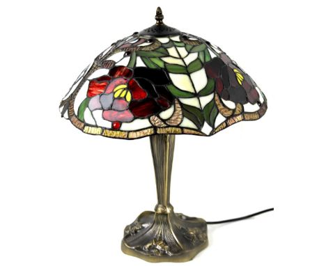 *An as new table lamp, with Tiffany style shade, with a repeat floral pattern predominately in red, yellow, green and cream, 